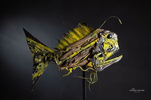 Deep Sea Fish, scultura giallo-verde in legno e metallo con antenna luminosa e denti metallici