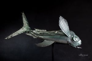 Flying Fish, scultura argentata in metallo recuperato con grandi pinne aperte simili ad ali
